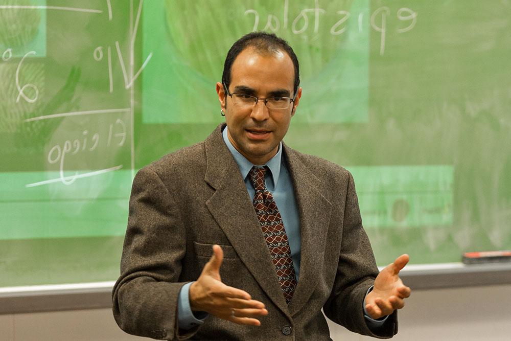 Professor speaking in front of chalkboard