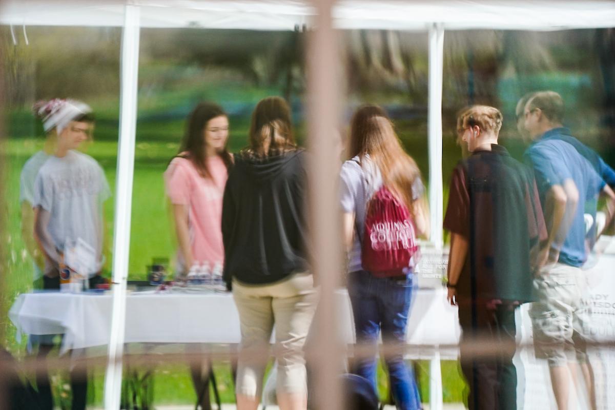 a Reflection on a window of students gathered at a table talking 