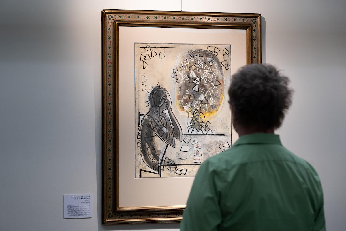 Person facing away from camera looks at art by Gilot