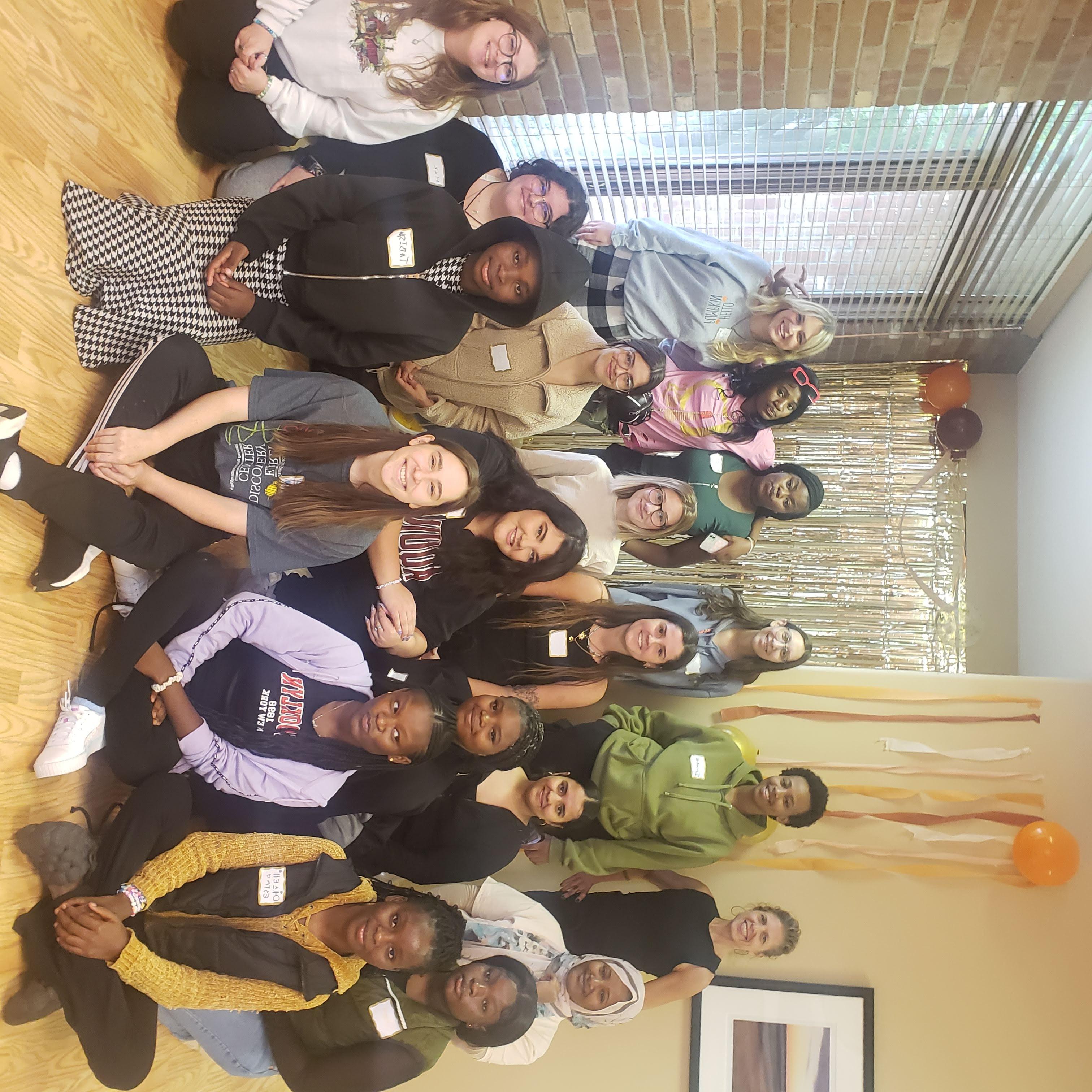 Students and refugee teens pose together at fall celebration